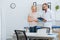 portrait of chiropractic in white coat with notepad and female patient having conversation