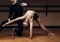 Portrait of a choreographer& x27;s teacher helping a little girl to pose correctlyin a dance studio, dimmed light. place