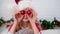 Portrait Christmas girl. Smiling child in Santa Claus hat having fun looking into the camera making crazy funny face