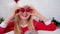 Portrait Christmas girl. Smiling child in Santa Claus hat having fun looking into the camera making crazy funny face