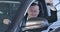 Portrait of chubby Caucasian man bragging car keys at camera and smiling. Happy owner sitting in vehicle and looking out