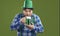 Portrait of chubby Irish man in party hat drinking green beer on Saint Patrick's Day