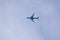 A portrait of a civilian airplane high up in the sky flying by. The belly of the airliner is visible