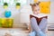 Portrait of clever little girl sitting with book on the floor