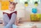 Portrait of clever little girl sitting with book on the floor