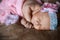 Portrait close-up newborn little girl who sleeps soap, soft pink scarf covered with lace satin flower