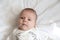 Portrait of a close-up of the surprised and serious face of the baby girl who lies in bed. Three-year-old girl