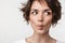 Portrait closeup of cheerful woman with short brown hair in basic t-shirt making fish face with lips at camera