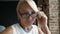 Portrait of Closeup of face lovely middle-aged woman putting on glasses smiling into camera, healthy eyesight. Indoors