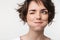 Portrait closeup of joyful woman with short brown hair in basic t-shirt smiling and looking aside