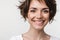 Portrait closeup of pretty woman with short brown hair in basic t-shirt smiling at camera