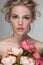 Portrait closeup of a young beautiful blonde woman with fresh flowers.