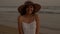 Portrait of a closeup of a young smiling girl in a hat on the shore of the Pacific Ocean. Woman in a white dress at