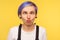 Portrait of comic hipster girl looking cross eyed, making silly awkward expression. yellow background, studio shot