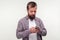 Portrait of concentrated bearded man using smartphone looking serious focused, reading message. white background