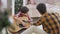 Portrait of concentrated boy holding guitar as teenage brother teaching him playing musical instrument. Focused cute