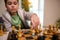 Portrait of a concentrated handsome smart boy picking up a chess piece while making move on chess board. Chess game for clever