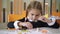 Portrait of concentrated schoolgirl sculpting plasticine in school. Focused beautiful little Caucasian girl modelling