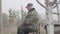 Portrait of concentrated senior Caucasian fisherman outdoors. Side view of old man sitting on chair on cloudy morning