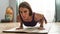 Portrait of concentrated young woman exercising, doing Four Limbed Staff yoga pose on a mat in living room at home