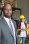 Portrait of confident African American male businessman with female worker standing in background