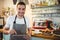 Portrait of confident barista using digital tablet at cafe