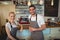 Portrait of confident baristas standing at counter