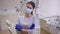 Portrait of confident beautiful woman in face mask crossing hands looking at camera standing at dentist chair in