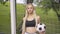 Portrait of confident beautiful woman posing with ball at soccer net. Camera approaches to smiling slim Caucasian