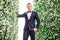 Portrait of confident bridegroom standing amidst flower decorations