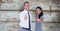 Portrait of confident business people showing thumbs up against wooden wall