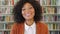 Portrait of a confident businesswoman in front of bookshelves. Beautiful and stylish Afro female entrepreneur or lawyer