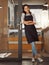 Portrait of confident businesswoman leaning on her business door. Young boss arms crossed in her store entrance