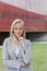 Portrait of confident businesswoman standing with hand on chin against office building