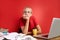 Portrait of confident caucasian blonde female sitting at office desk with laptop and papers