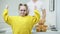 Portrait of confident cheerful Caucasian girl in eyeglasses showing strength gesture looking at camera with