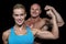 Portrait of confident cheerful man and woman flexing muscles