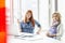 Portrait of confident creative businesswomen sitting at desk in office