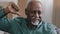 Portrait of confident elderly african american man indoors looking at camera show thumb down negative emotion mature old