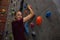 Portrait of confident female athlete climbing wall in gym