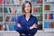 Portrait of confident female college student inside library in educational building