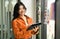 Portrait of confident female designer standing by glass window with color swatch samples chart