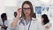 Portrait of confident female medical doctor in glasses and white coat with stethoscope on the neck smiling to the camera