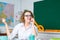 Portrait of confident female teacher near blackboard in classroom at school. Happy teacher.