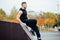 Portrait of a confident fitness guy. Man poses on skate ramp, against the background the autumn forest. Fall.