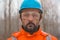 Portrait of confident forestry technician in woodland