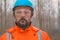 Portrait of confident forestry technician in woodland