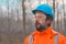 Portrait of confident forestry technician in woodland