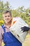 Portrait of confident gardener carrying sack in plant nursery