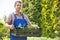 Portrait of confident gardener holding crate of potted plants